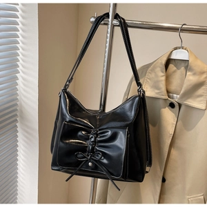 Detailansicht der schwarzen Hobo-Tasche mit Schleifendekor und weißen Kontrastnähten