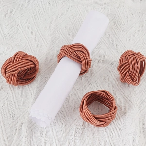 Set mit vier geflochtenen Serviettenringen in Roségold für elegante Tischdekoration