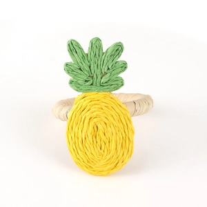 Detail of handmade raffia woven pineapple napkin ring with intricate yellow fiber textures