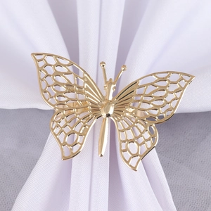 Detailed macro view of a golden butterfly napkin ring with intricate hollowed patterns