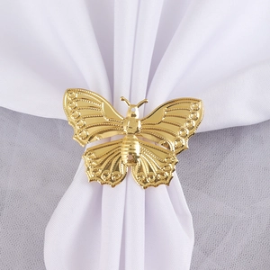 Golden hollow butterfly napkin ring with mirror finish on white fabric background