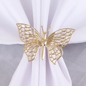 Macro view of golden hollow-out butterfly napkin ring with detailed metal mesh wings