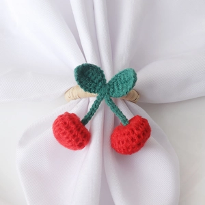 Rond de serviette cerise crocheté à la main avec fruits rouges et feuilles vertes sur lin