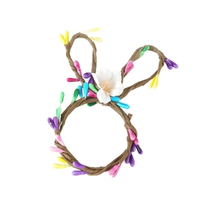 Servilletero de Pascua con orejas de conejo, bayas de colores y una pequeña flor blanca