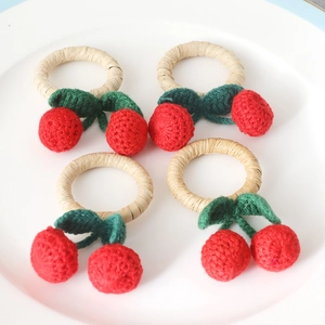 Détail de 4 ronds de serviette cerise faits main sur une assiette blanche