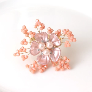 Detalle del servilletero floral de cristal rosa con perlas y cuentas de alambre