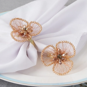 Detailed view of fan-shaped crystal floral napkin rings with gold wire and amber beads