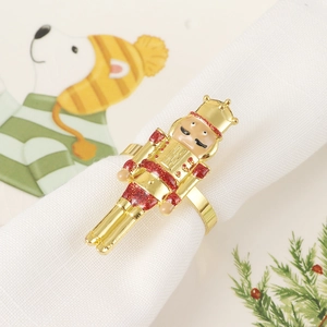 Detailed view of nutcracker napkin ring with red glitter uniform and gold finish