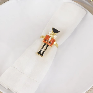 Detail of a festive Nutcracker napkin ring on a white plate for holiday table settings