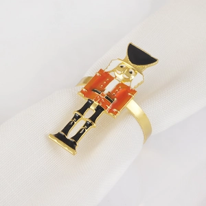 Close-up of nutcracker soldier napkin ring with red and gold enamel details on fabric