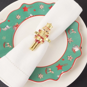 Macro shot of gold nutcracker soldier napkin ring on a white cloth for table decor