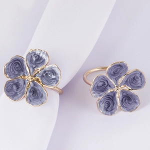 Detail of white flower napkin ring with purple marble enamel and gold metal frame