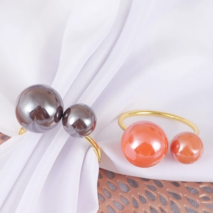 Elegant U-shaped gold metal napkin rings with pearl and coral orange beads decoration