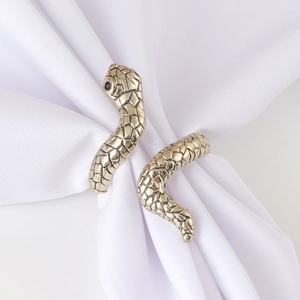 Elegant antique gold snake napkin ring with detailed scale texture on white cloth