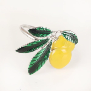 Detail of yellow enamel lemon napkin ring with silver metal base and green leaves