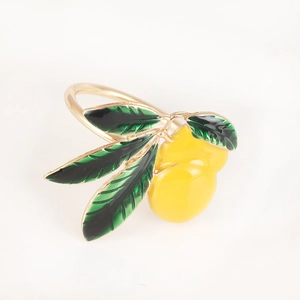 Detail view of yellow enamel lemon napkin ring with green leaves on gold metal loop