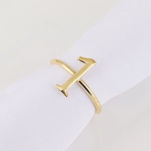 Minimalist golden vertical bar napkin ring with a polished mirror finish on a stand