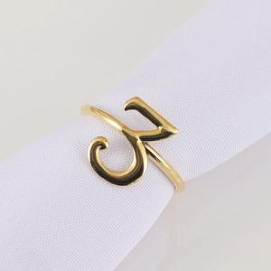 Macro shot of gold napkin ring featuring Arabic calligraphy on a white fabric napkin