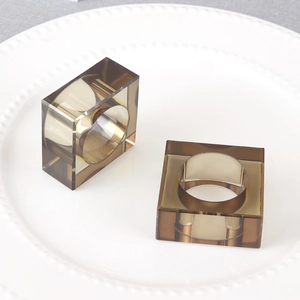Detail view of two smoky amber resin napkin rings on a white plate for holiday table decor