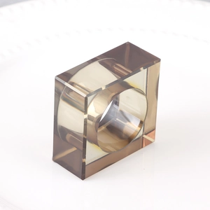 Modern translucent smoky grey resin napkin ring with geometric square design on white background