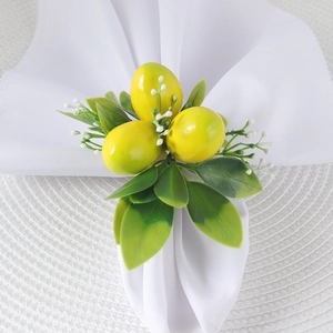 Three bright yellow lemon napkin rings with green leaves for summer table decoration