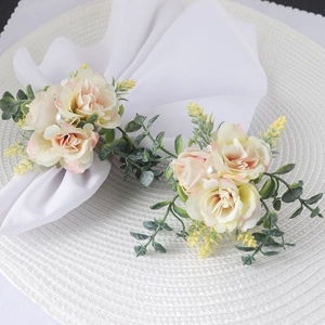 Detail of pink faux rose napkin rings with green leaves and white pearls for weddings