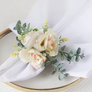 Close-up of rose napkin ring with eucalyptus leaves and a pearl on a white napkin