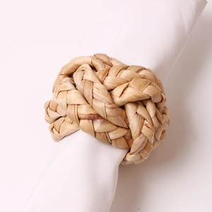 Handwoven natural corn husk napkin ring with spherical knot for rustic table decor