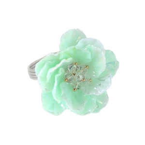 Mint green floral napkin ring with layered petals and a yellow bead on a white background