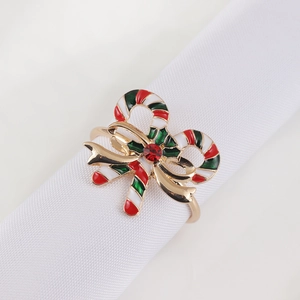 Close-up of Christmas bell wreath napkin ring with red bow and candy cane details