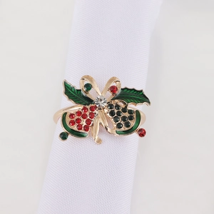 Detail of Christmas napkin ring with golden bells, holly leaves and colorful rhinestones