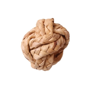 Handwoven natural corn husk napkin ring with textured sphere knot for rustic table decor