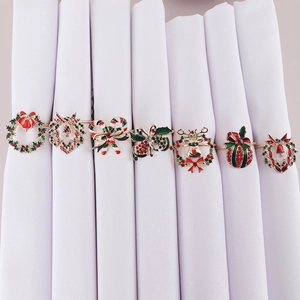 Set of seven Christmas wreath and bell napkin rings in festive gold-tone metal designs
