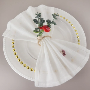 Rustic mushroom napkin ring with green leaves and hemp rope on a white dinner plate