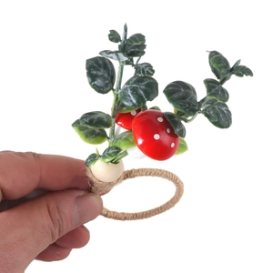 Forest style napkin ring featuring woven hemp rope with green leaves and red mushrooms
