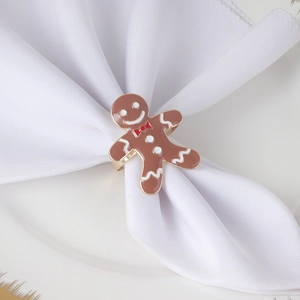 Christmas gingerbread man napkin ring with gold finish and enamel details on white cloth
