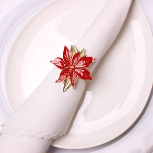 Rond de serviette fleur de poinsettia rouge avec bord doré sur serviette blanche