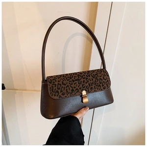 Detail of vintage brown leather underarm bag featuring leopard print flap and gold clasp
