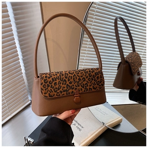 Close-up of a vintage brown leather underarm bag with leopard print pony hair flap
