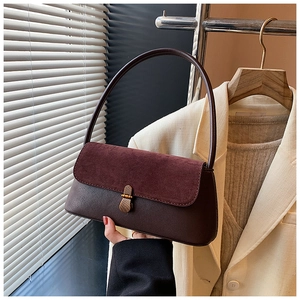 Detail of the vintage contrast shoulder bag showing textured suede flap and brass buckle