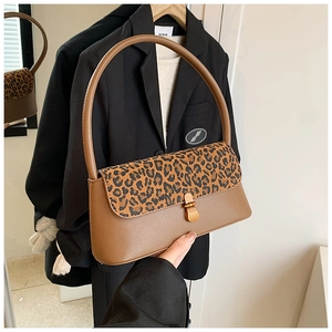 Détail du sac baguette à rabat léopard avec fermoir doré et poignée en cuir marron
