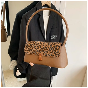 Détail du rabat léopard et du fermoir métallique sur le sac baguette en cuir marron