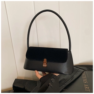 Detail of vintage black underarm bag featuring suede patchwork and wood texture buckle