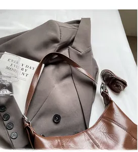 Detail of vintage oil wax leather crescent bag with adjustable straps and texture