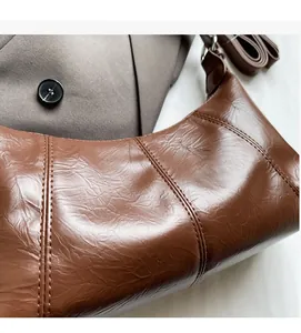 Detail of vintage oil wax leather shoulder bag showing texture and stitching