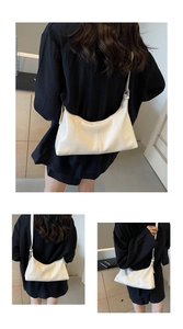Detail of adjustable strap and minimalist stitching on white faux leather hobo bag