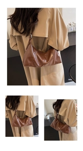 Detail of the pleated brown vintage leather crescent bag with adjustable strap and metallic buckle