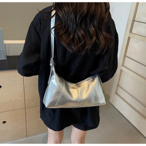 Detail of silver metallic hobo bag featuring wrinkled leather texture and adjustable strap