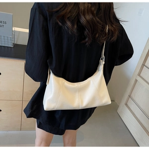 Detail of cream crescent bag featuring natural wrinkled texture and vertical stitching