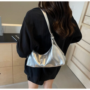Close-up of a metallic silver crescent hobo bag featuring stylish quilted texture on shoulder